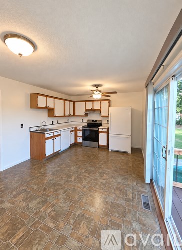 A kitchen with tile flooring and wooden cabinets.