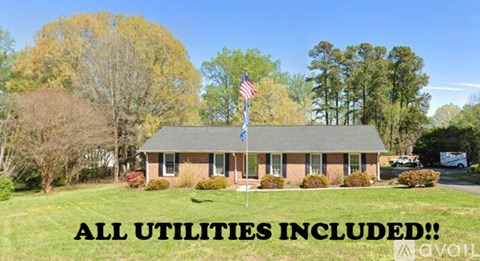 A house with a flag on the lawn and a sign that says "ALL UTILITIES INCLUDED!".