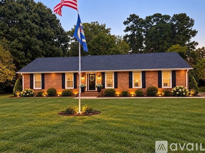 A house with a lawn and a flag on a pole in front.