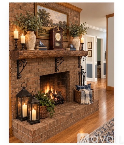 A fireplace with a painting above it and candles on the mantle.
