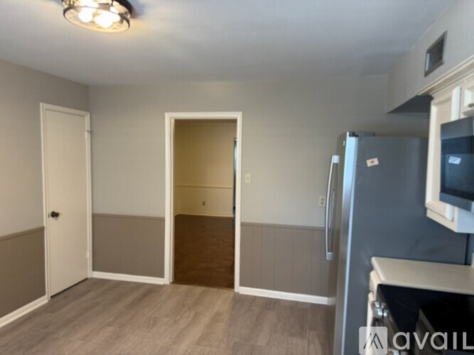 A kitchen area with a refrigerator and a microwave.
