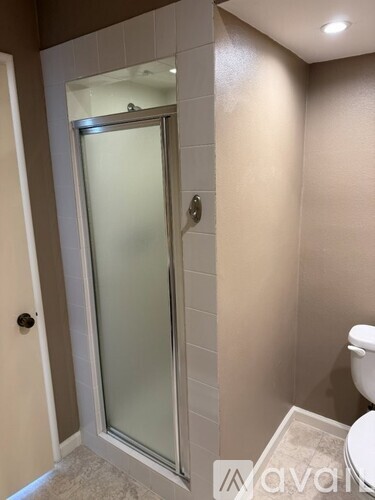 A bathroom with a toilet and a glass door.