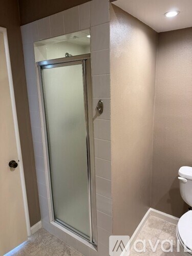A bathroom with a toilet and a glass door.