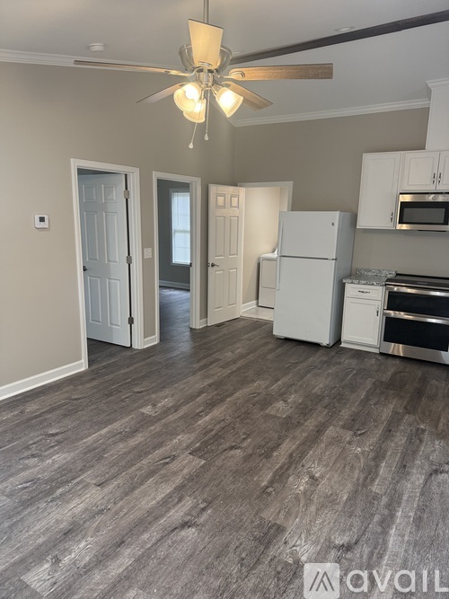 A kitchen with a white fridge and a ceiling fan.