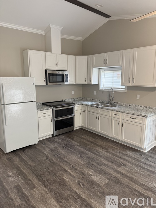 A kitchen with white appliances and cabinets.