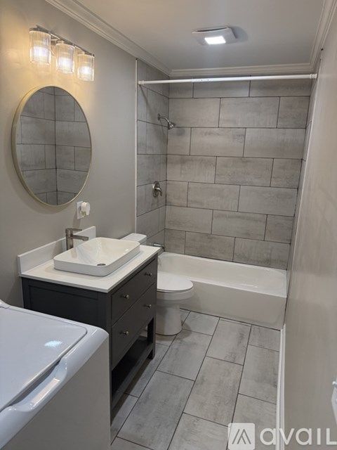 A bathroom with a toilet, sink, and tub.