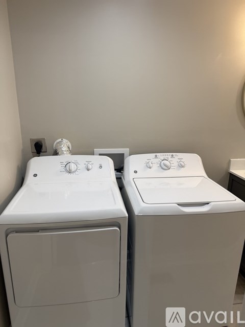 Two white front loading washing machines in a laundry room.