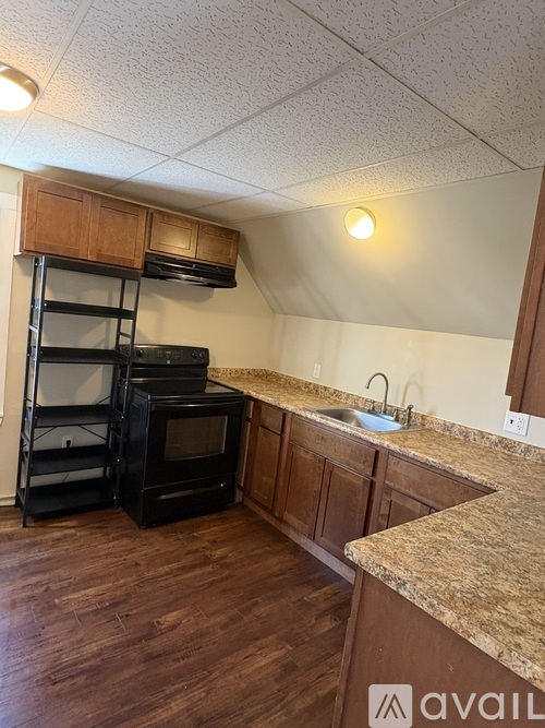 A kitchen with wooden cabinets and a black oven.
