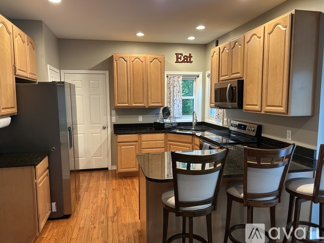 A kitchen with wooden cabinets and a black refrigerator.