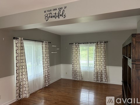 A room with a quote on the ceiling and patterned curtains.