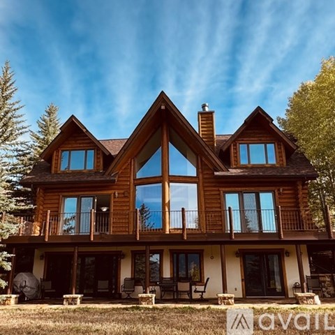 A large wooden house with a balcony and a chimney.