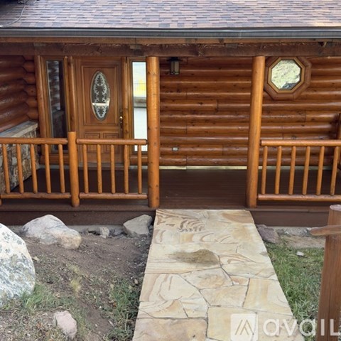 A wooden cabin with a stone walkway leading to the front door.