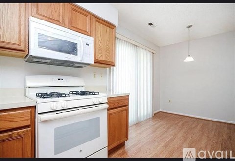 A kitchen with a white stove and a white microwave above it.