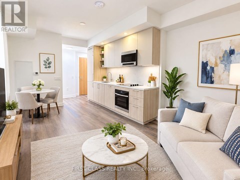 A modern living room with a white sofa, a coffee table, and a kitchen area in the background.