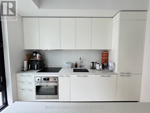 A kitchen with white cabinets and appliances.