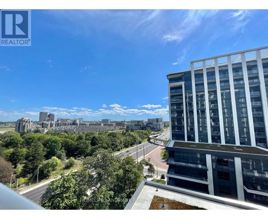 A view from a high-rise building looking out over a cityscape with a clear blue sky.