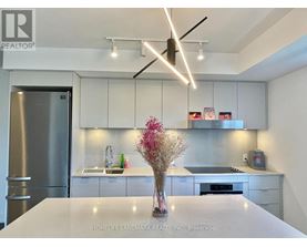 A modern kitchen with a white countertop and stainless steel appliances.