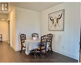 A dining room with a table and chairs and a painting of a bull's head.
