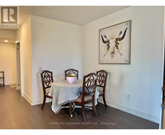 A dining room with a table and chairs and a painting of a bull's head.