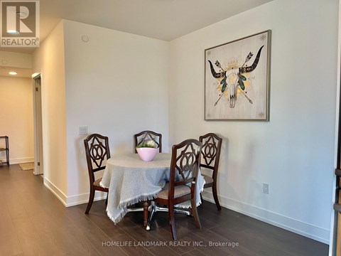 A dining room with a table and chairs and a painting of a bull's head.