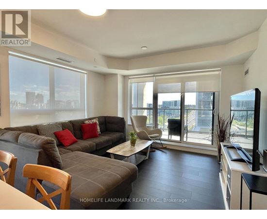 A living room with a grey couch and a wooden chair.