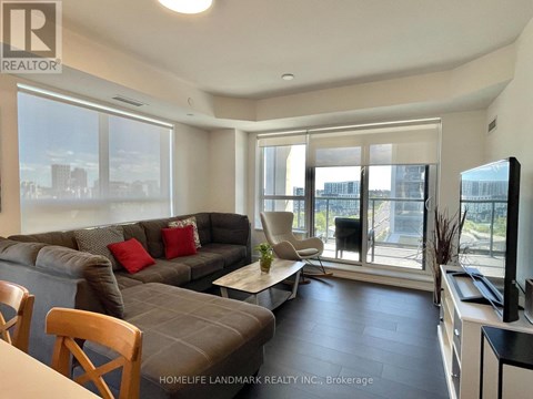 A living room with a grey couch and a wooden chair.
