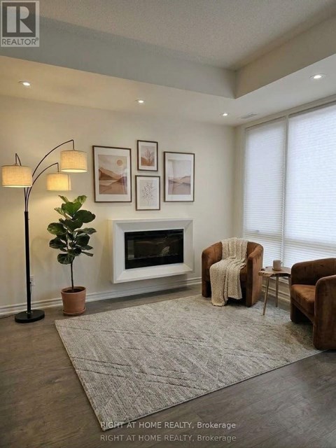 A living room with a fireplace, two chairs, and a floor lamp.