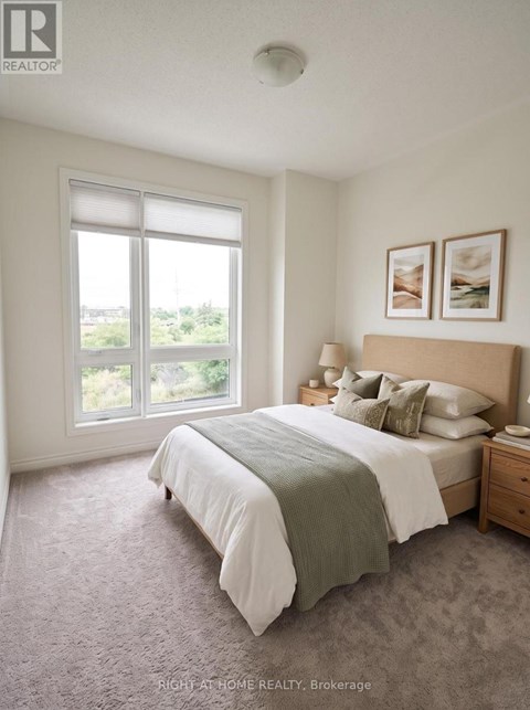A bedroom with a large bed and a window overlooking a green landscape.