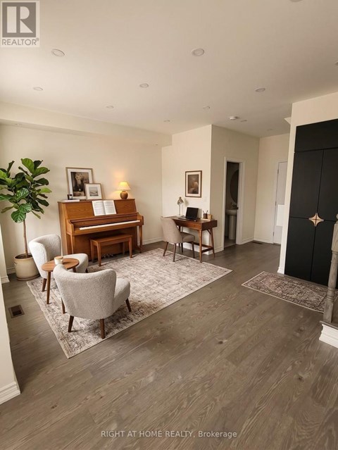 A living room with a piano and chairs.