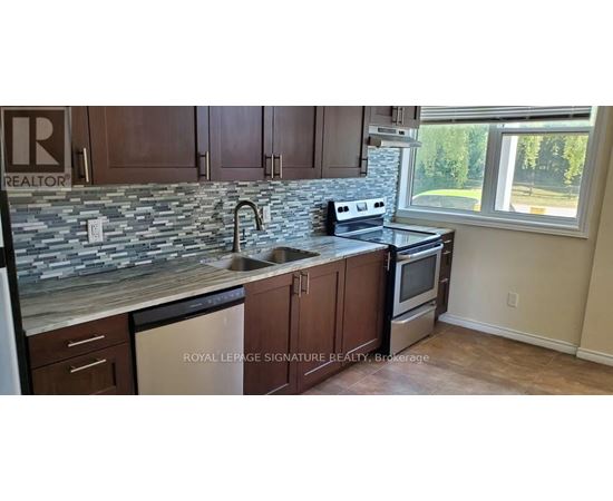 A kitchen with a stone counter top and a window.