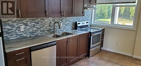 A kitchen with a stone counter top and a window.