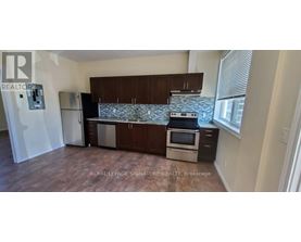 A kitchen with a refrigerator, stove, and cabinets.