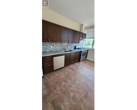 A kitchen with brown cabinets and a stone counter.