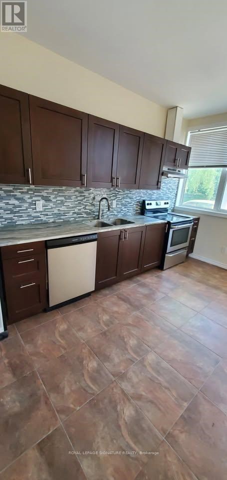 A kitchen with brown cabinets and a stone counter.