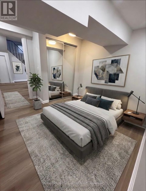 A bedroom with a large bed and a plant.