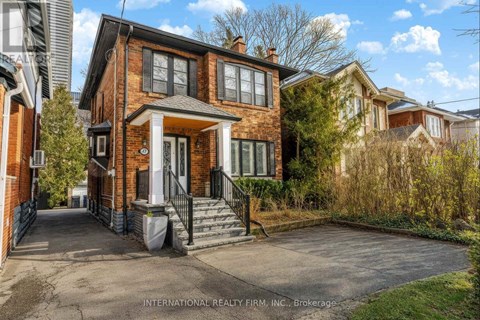 A brick house with a black gate and a small front yard.