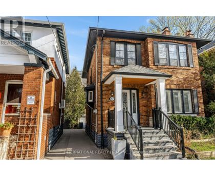 A brick house with a porch and a sign that says International Realty.