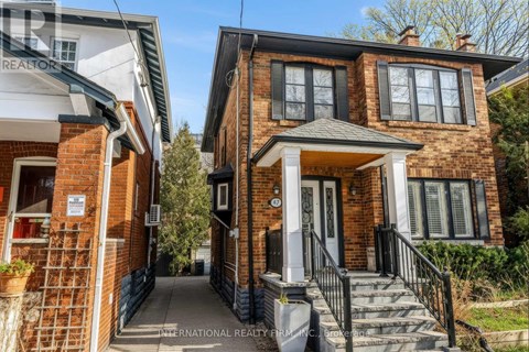 A brick house with a porch and a sign that says International Realty.