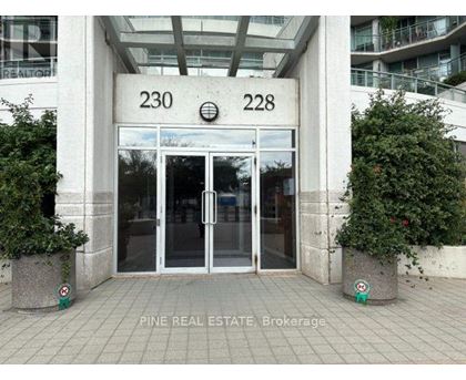 The image shows the entrance to a building with the numbers 230 and 228 on the wall above the glass doors.
