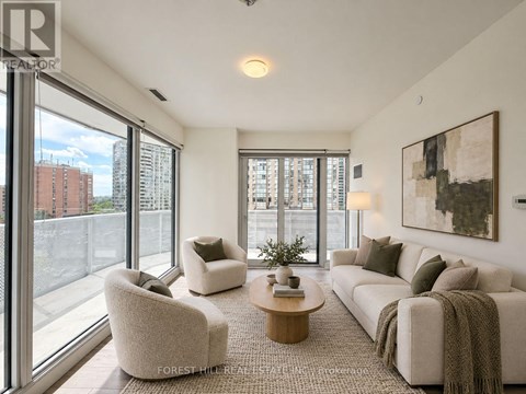 A living room with a couch, chairs, and a coffee table.