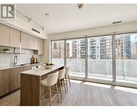 A kitchen with wooden floors and white chairs.