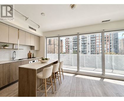 A kitchen with wooden floors and white chairs.