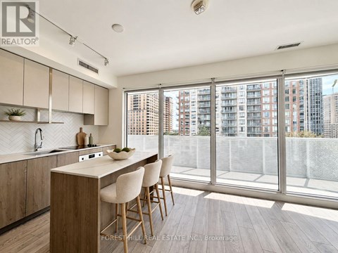 A kitchen with wooden floors and white chairs.