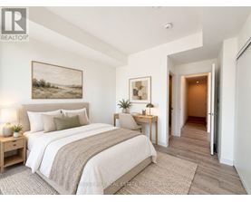 A bedroom with a large bed and a painting on the wall.