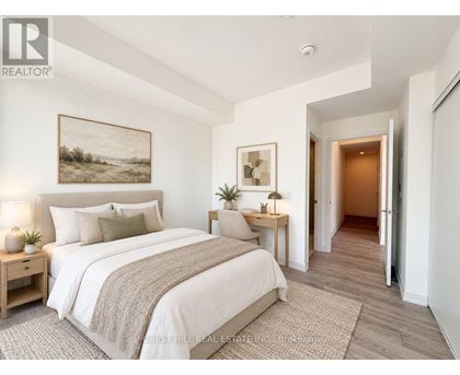 A bedroom with a large bed and a painting on the wall.
