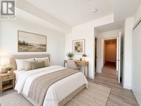 A bedroom with a large bed and a painting on the wall.