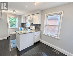 A kitchen with a granite countertop and white cabinets.