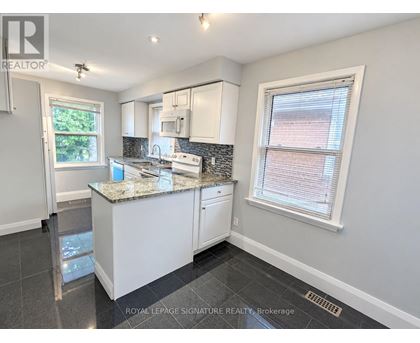 A kitchen with a granite countertop and white cabinets.