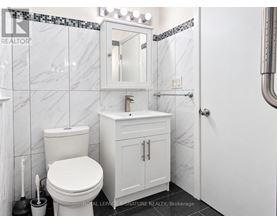 A white toilet and sink in a bathroom.