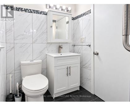 A white toilet and sink in a bathroom.